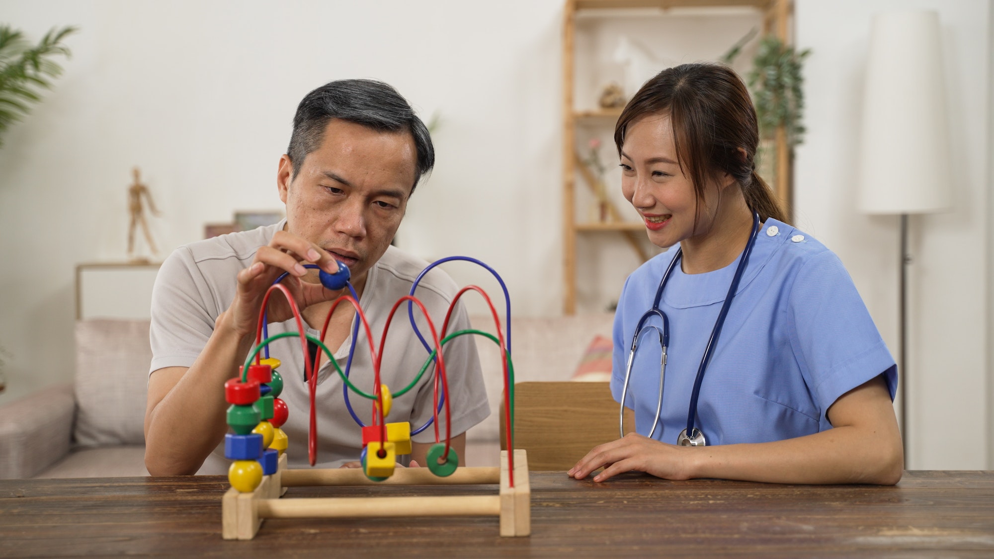elderly man exercising hand muscle with nurse